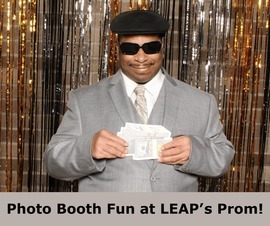 Consumer at Prom wearing gray suit, sunglasses, black hat, holding money cut-out in a photo booth w/black, silver, gold streamers. Along bottom is a gray box with bold, black text, 